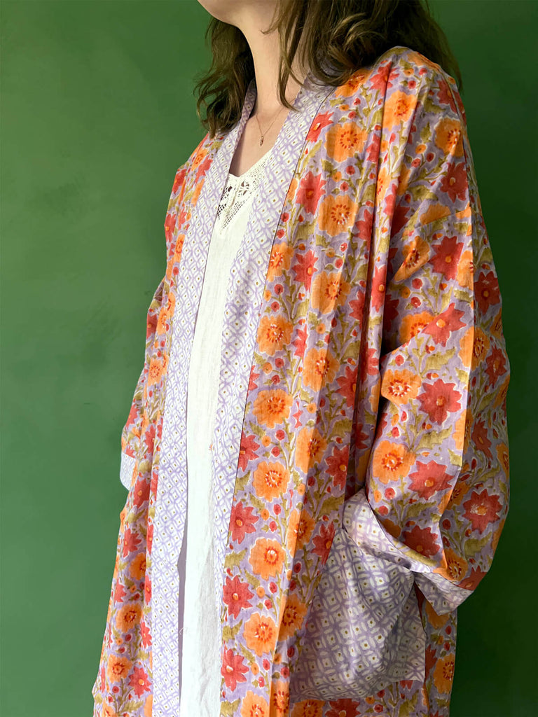 A close-up of a model wearing Bohemia floral block print cotton robe with contrasting pockets and trim.