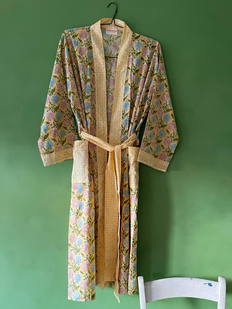 A stylish cotton robe in buttermilk yellow with powder blue and vintage pink blooms, featuring pockets and a matching belt by Bohemia