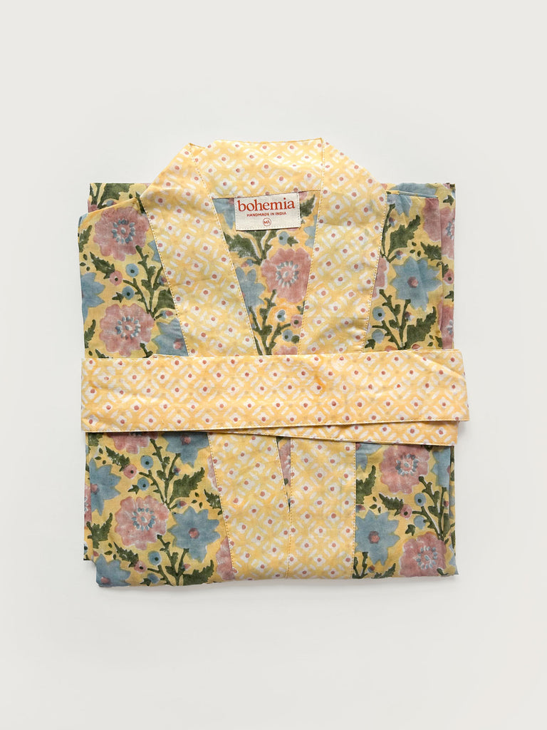 Flat-folded cotton robe in buttermilk yellow with complementary floral block prints on a white background | Bohemia