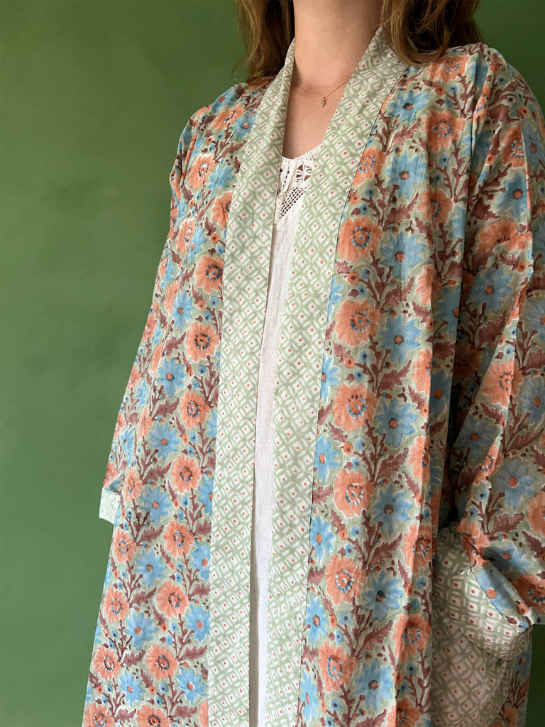 A close-up of a model wearing Bohemia floral block print cotton robe with contrasting pockets and trim.