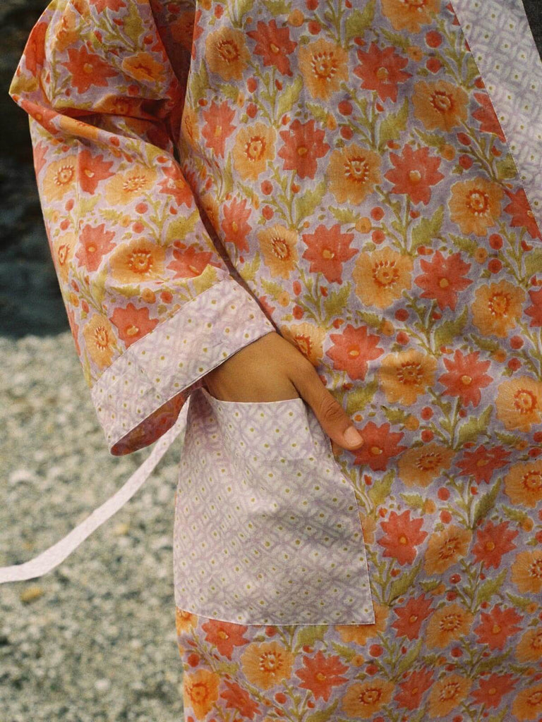 Close up of a model with hand in pocket of a lilac and orange Bohemia block print robe.