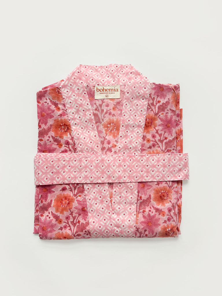 Flat-folded cotton robe in vintage pink with complementary block print floral patterns and a belt on a white background | Bohemia