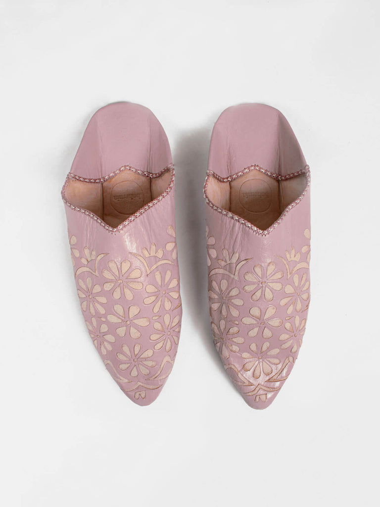 A pair of vintage pink leather Moroccan decorative babouche slippers with a daisy pattern.