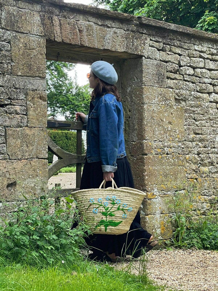 Natural handwoven basket with delicate sky blue embroidered Forget-Me-Not flowers, ideal for park outings and as a stylish accessory | Bohemia Design