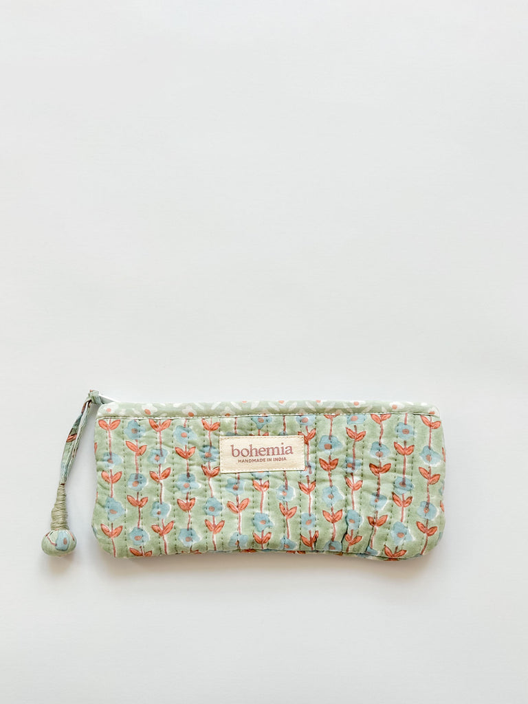 A long quilted pencil case, featuring a soft green-blue and terracotta ditsy floral pattern and a handcrafted zip pull by Bohemia Design