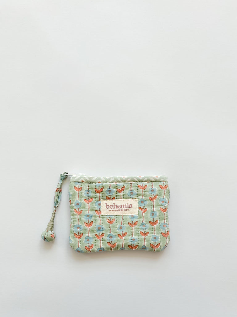 Small coin purse in a soft green-blue and terracotta ditsy floral print, featuring a handcrafted zip pull by Bohemia Design