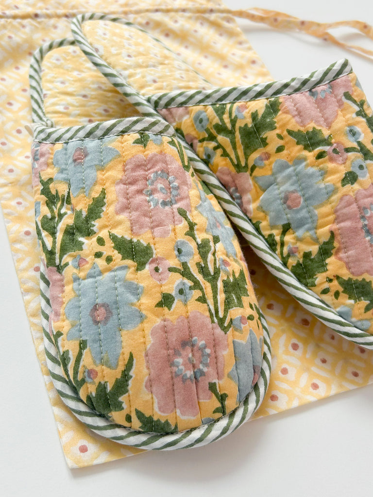 A closeup of beautiful creamy yellow quilted cotton house slippers with soft pink, blue and green floral pattern by Bohemia 