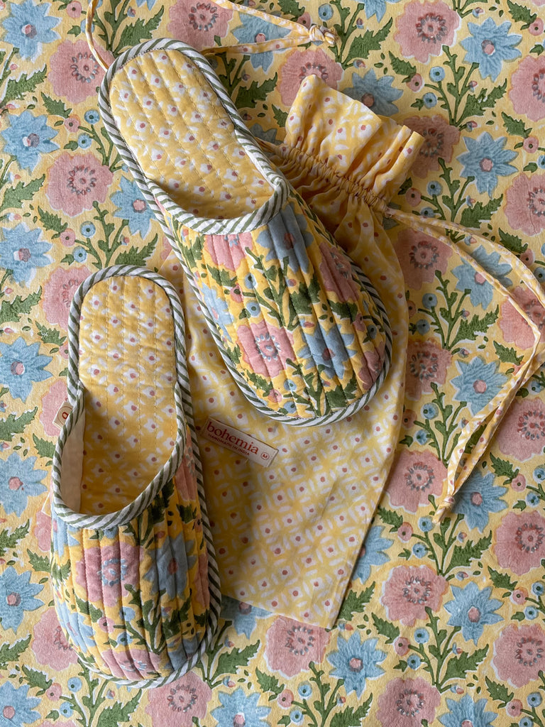 Quilted Yellow floral house slippers with a cotton drawstring bag on a matching floral patterned background by Bohemia 