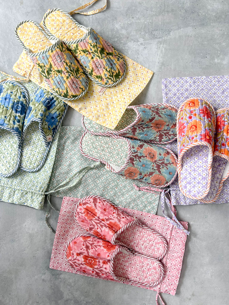 A collection of beautiful hand block print house slippers in a Floribunda pattern, paired with matching travel bags, on a grey background | Bohemia Design