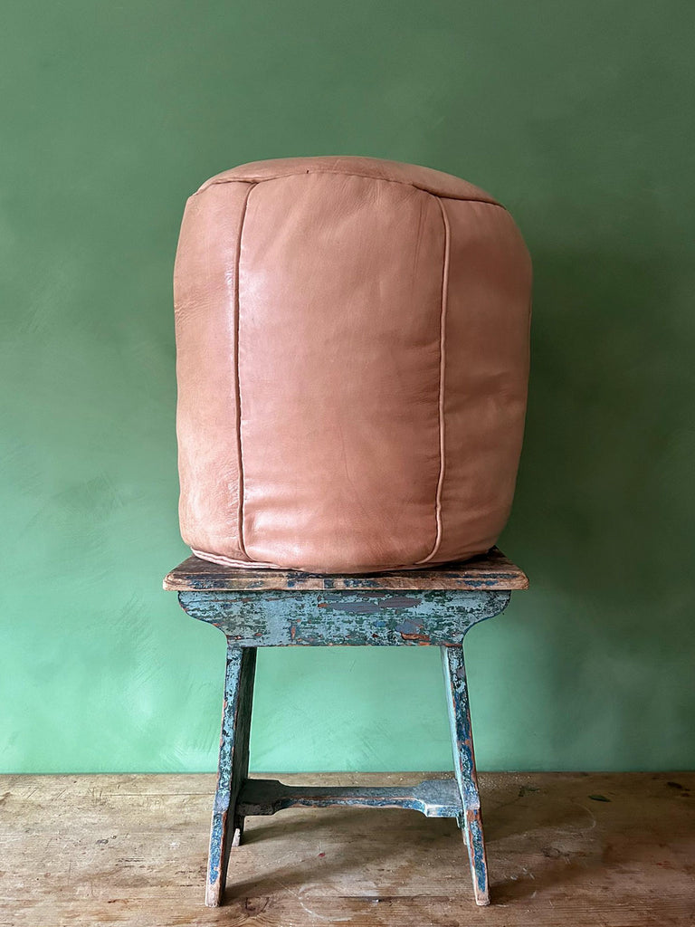 Side view of Moroccan drum-style leather pouffe in pale natural leather with decorative piping for a refined finish | Bohemia Design