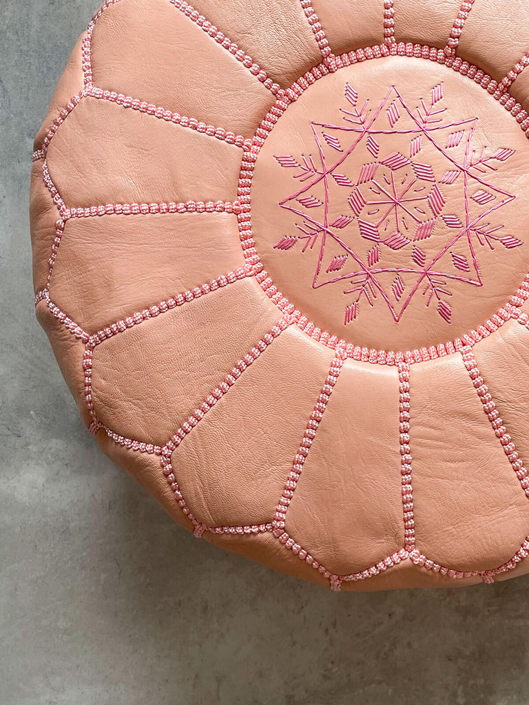 Close-up of a hand-embroidered star design in delightful pink thread on a soft leather Moroccan pouffe | Bohemia Design 