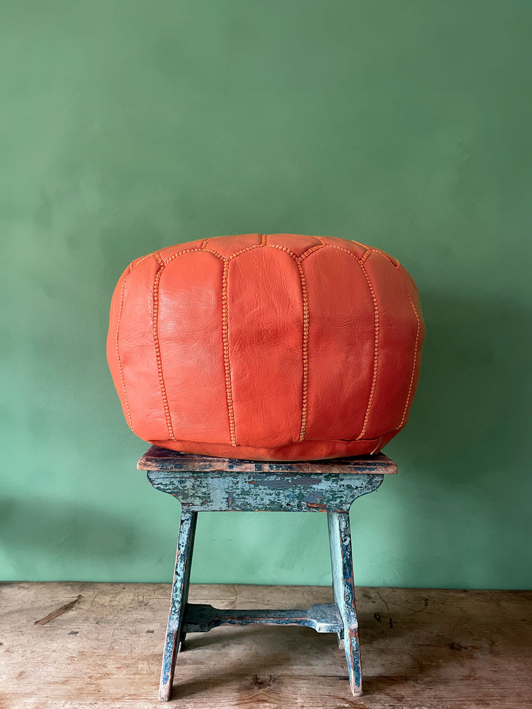 A side view of an authentic Moroccan leather pouffe with hand-stitched details in deep orange | Bohemia