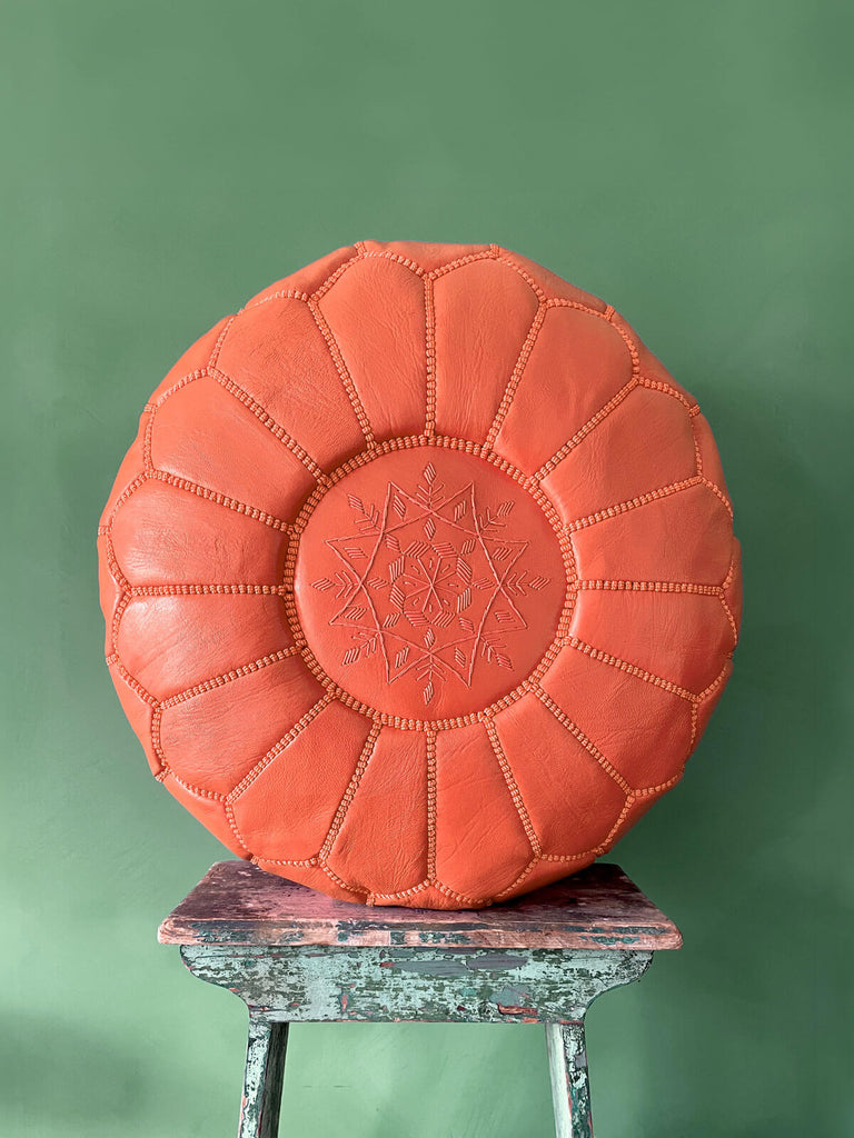 A traditional Moroccan leather pouffe design in vibrant deep orange with hand-embroidered star design | Bohemia