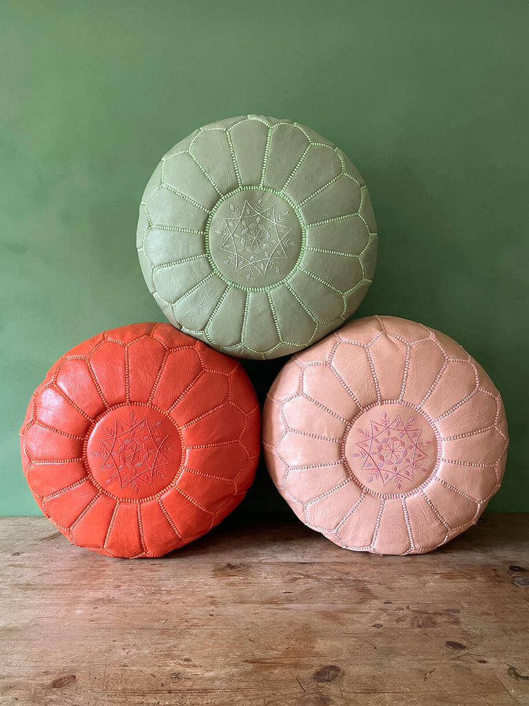 A trio of authentic Moroccan pouffes with a Nordic-inspired star design in various colours, set against a green wall | Bohemia