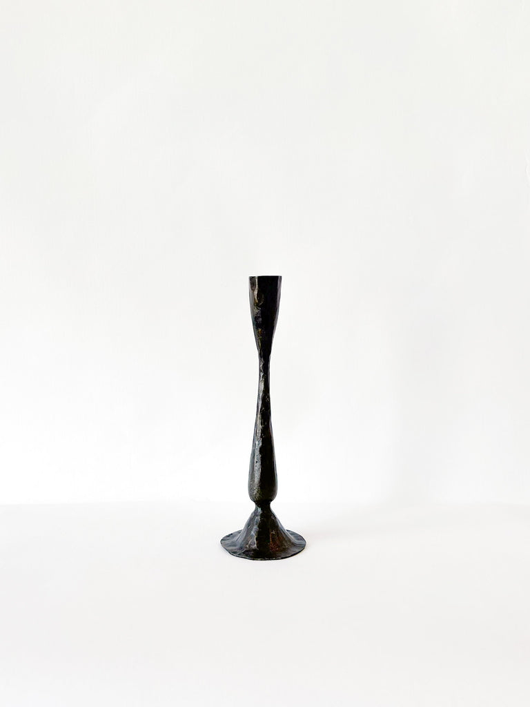 Small antique iron candle holder on white