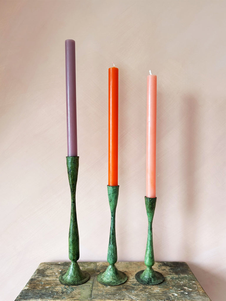 Three sizes if iron candle holders in antique verdigris patina finish, paired with a mix of colourful dining candles by BohemiaDesign