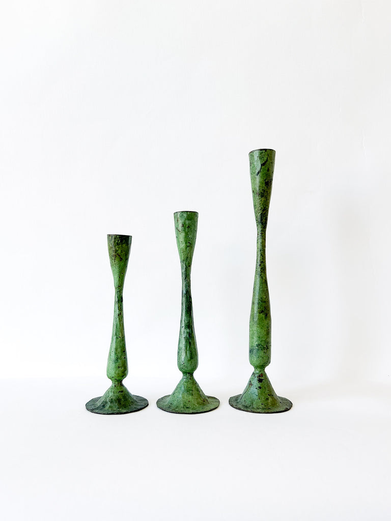 Three antique iron candle holders in verdigris patina finish on a white background by Bohemia
