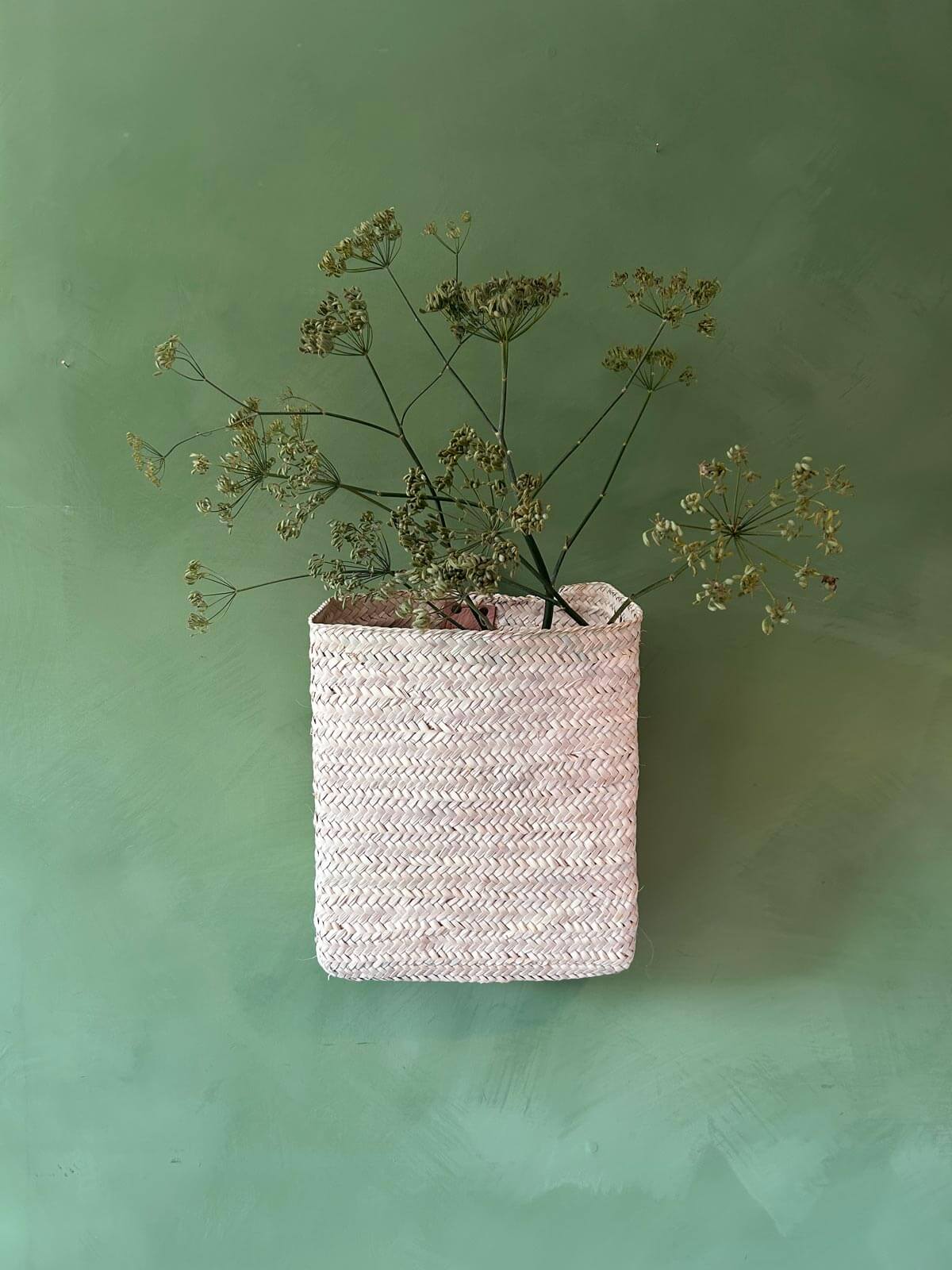 Moroccan hanging wall basket filled on a green background