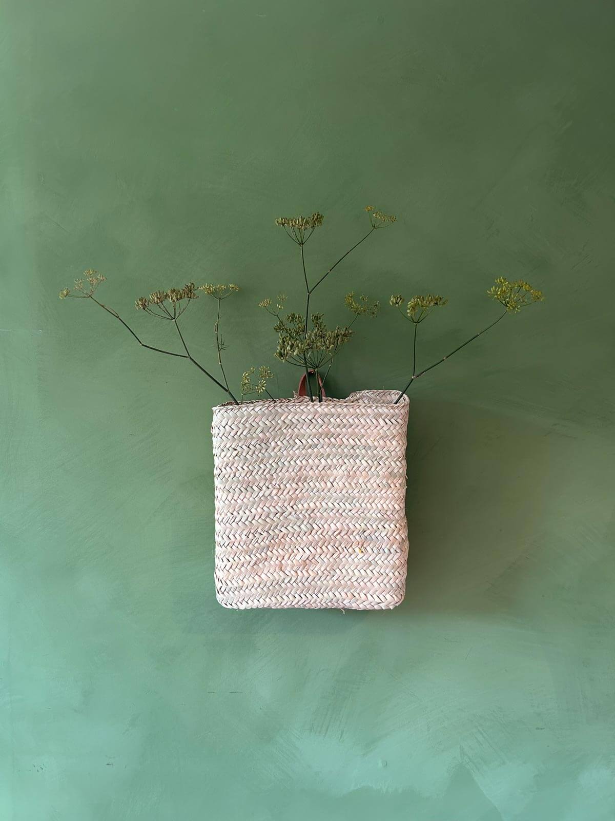 Moroccan hanging wall basket filled with foraged greenery