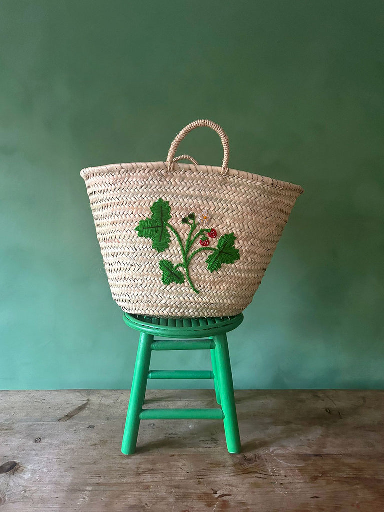 Sustainable handcrafted large basket bag featuring intricate wild strawberry embroidery against a vibrant green background | BohemiaDesign