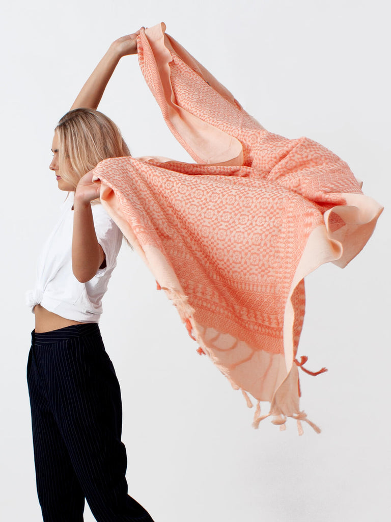 Model holding a lightweight, oversized cotton scarf