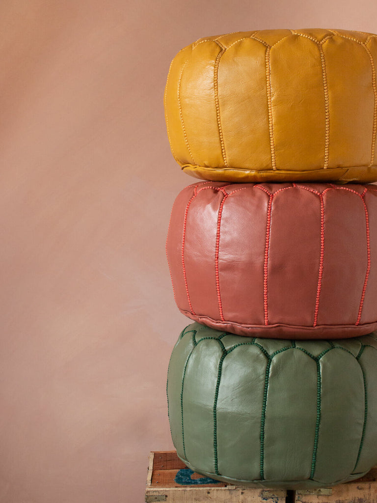 Three Moroccan leather pouffes stacked on top of each other to show the depth.