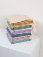 Pile of folded colourful Amalfi hammam towels by Bohemia Design