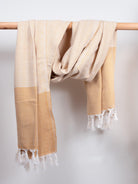 Nordic Dot Hammam Towel in mustard diamond pattern by Bohemia Design hanging on a wooden rod