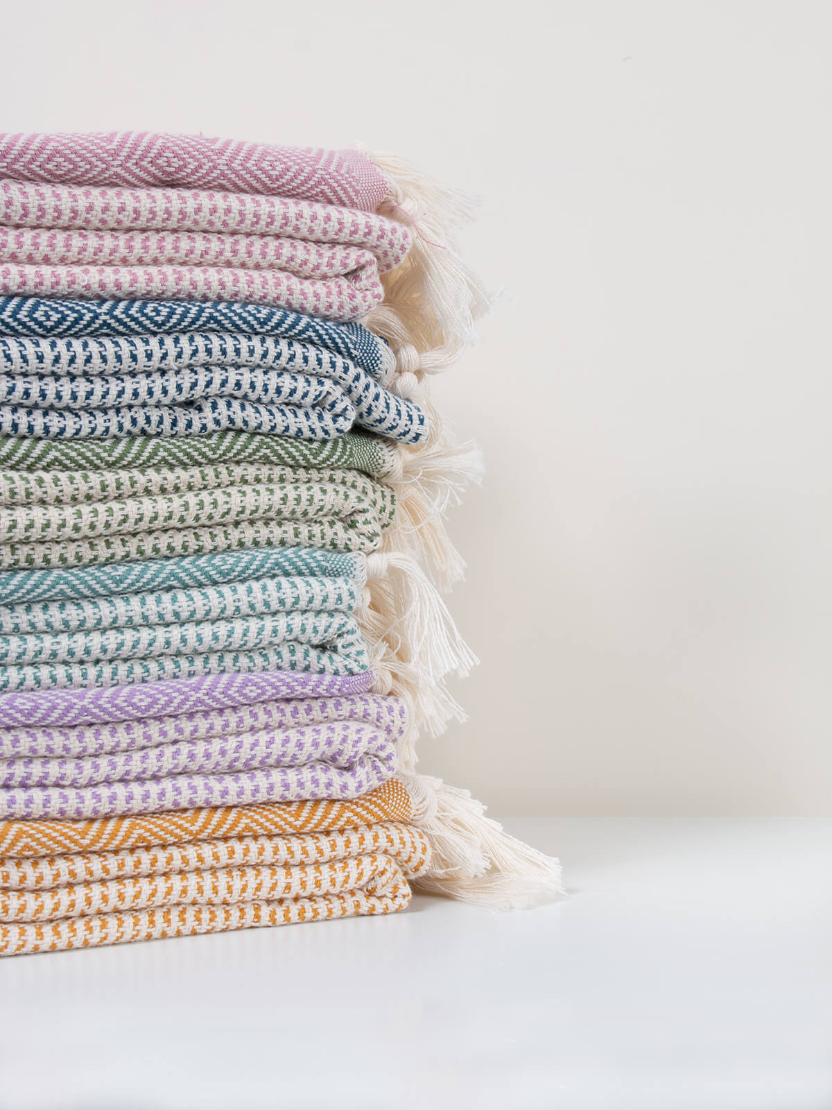 Pile of folded colourful Nordic Dot hammam towels by Bohemia Design